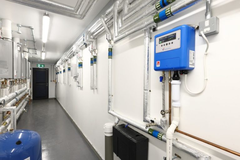 Black Horse Farm toilet and shower block internal corridor with boilers and pipework along the walls