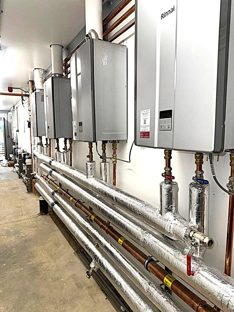 Black Horse Farm toilet and shower block View of corridor with boilers and pipework hung on the right hand side wall